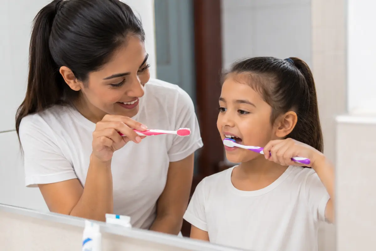 Parent teaching a child proper brushing techniques
