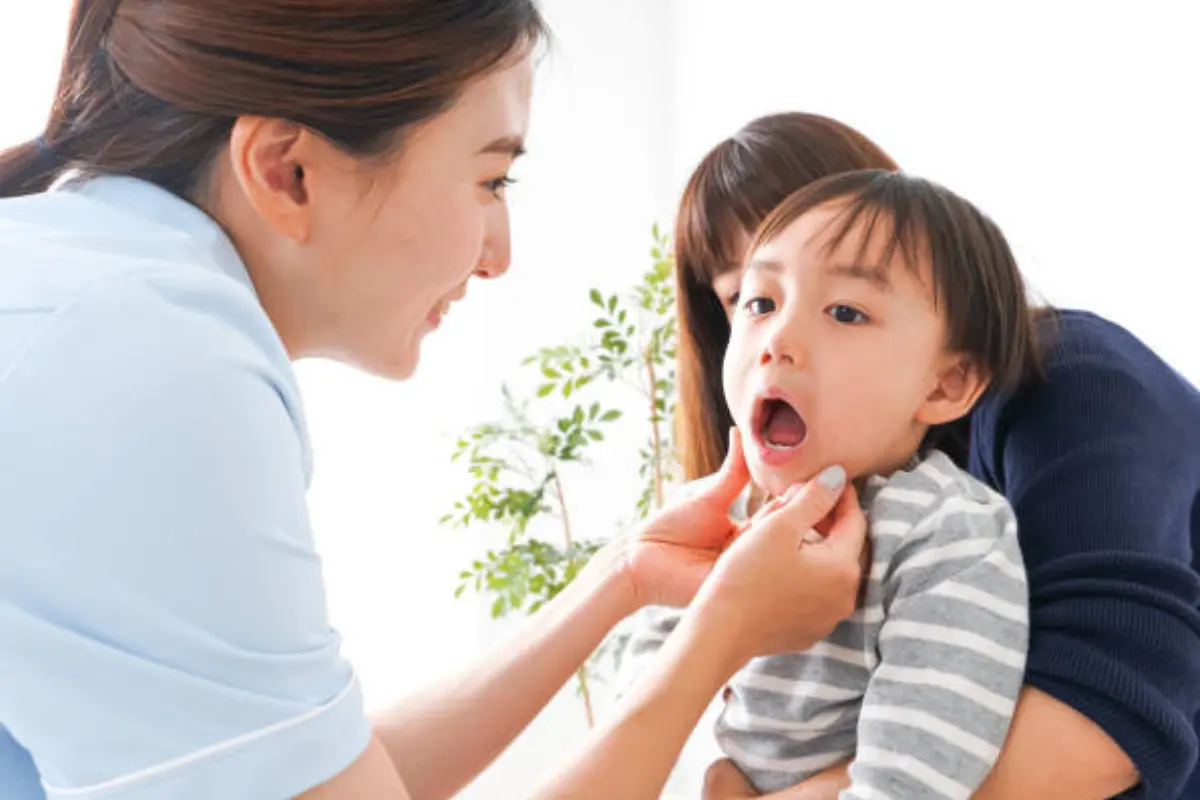Child receiving a dental checkup from a parent at home