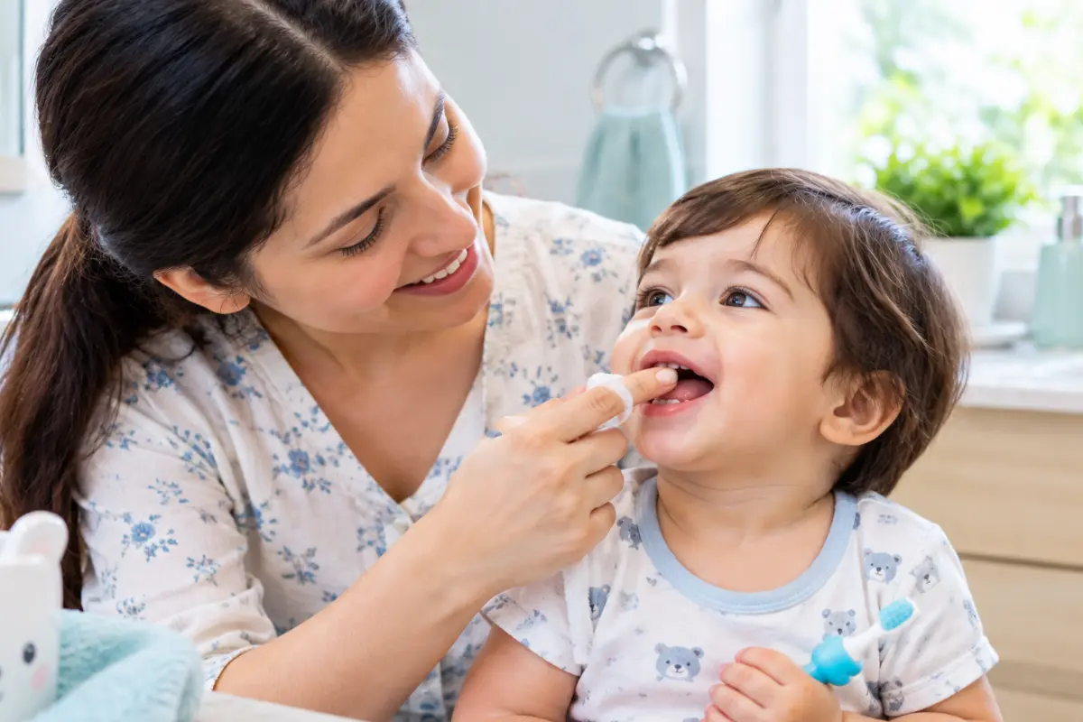 Parent caring for a baby's gums and first teeth