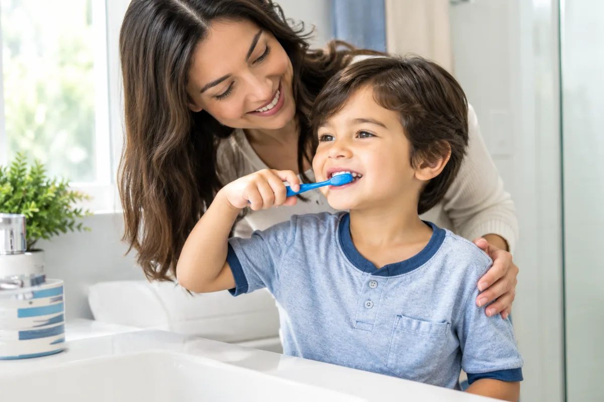 Is fluoride-free toothpaste better for kids? Parent supervising a young child brushing teeth.